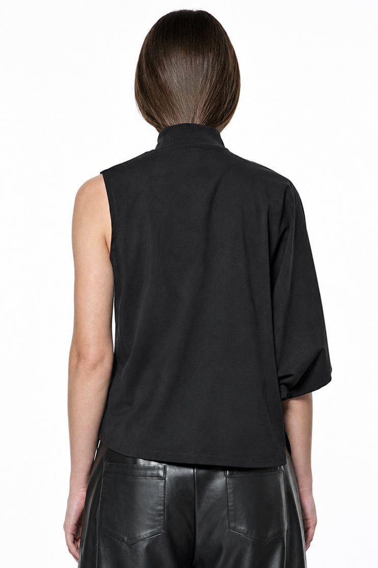 Back view of a model wearing a black mock neck one sleeve top against a white background.