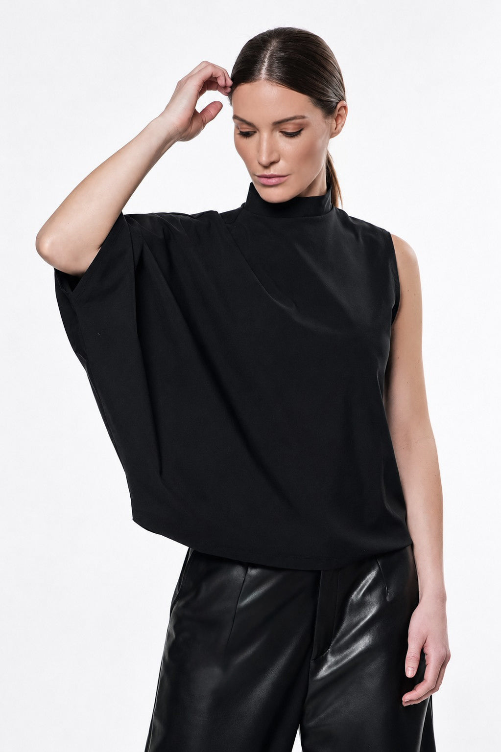 Woman wearing a black mock neck one sleeve top 