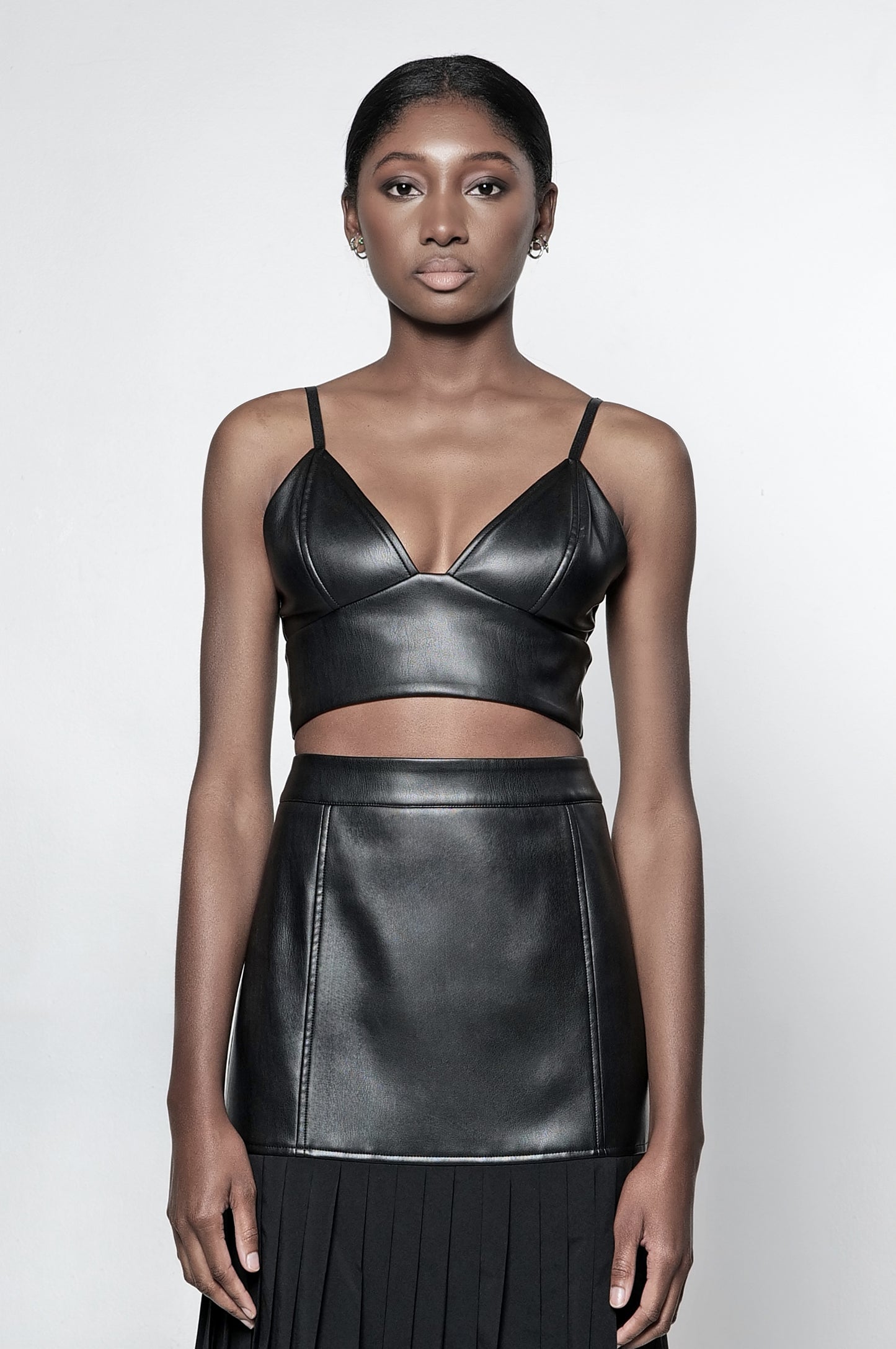 Model wearing a black vegan leather bralette