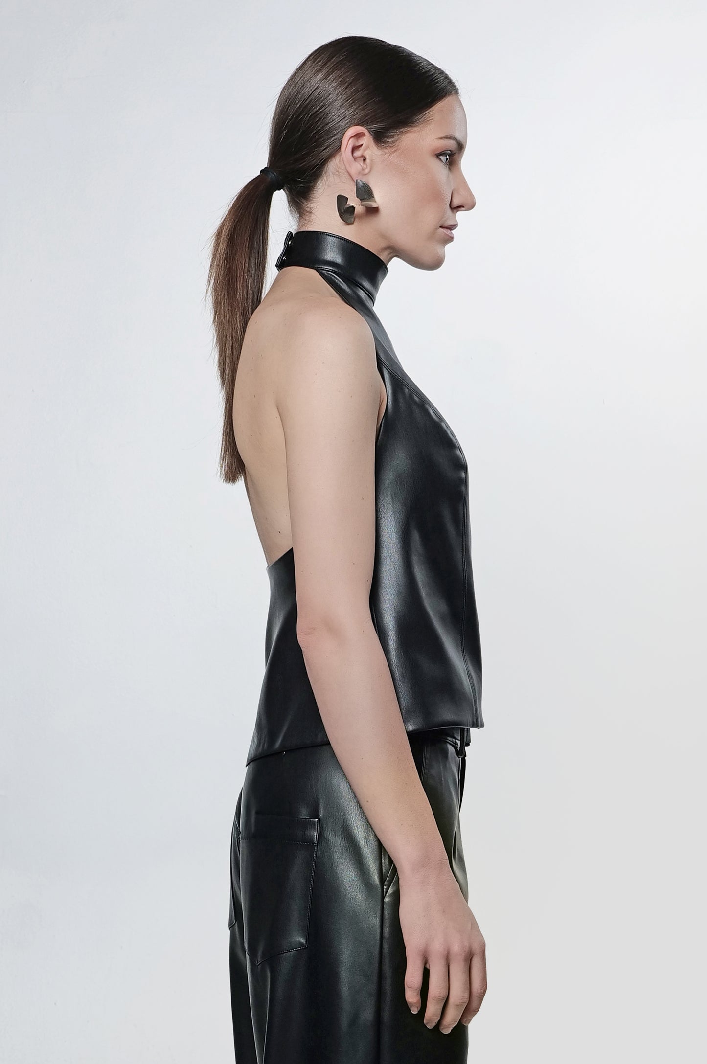 Model wearing black vegan leather halter top, side view
